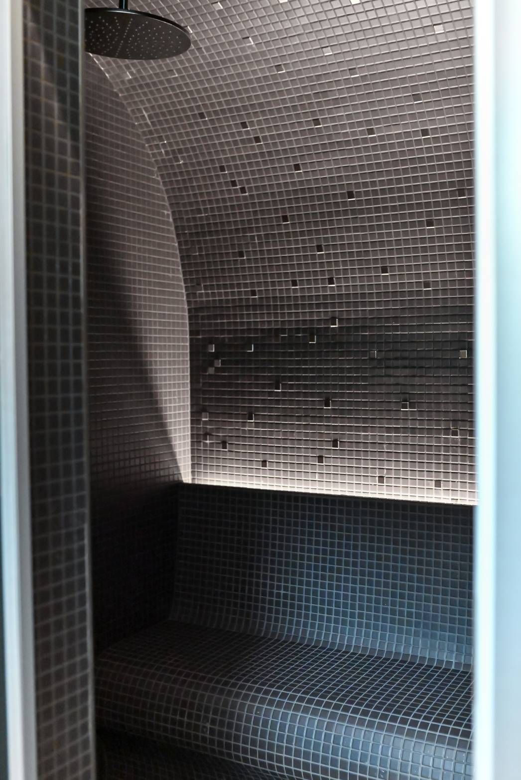 Mounted in a watertight profile behind the backrest of the steam room, the LED strip brings out the details of the wall.